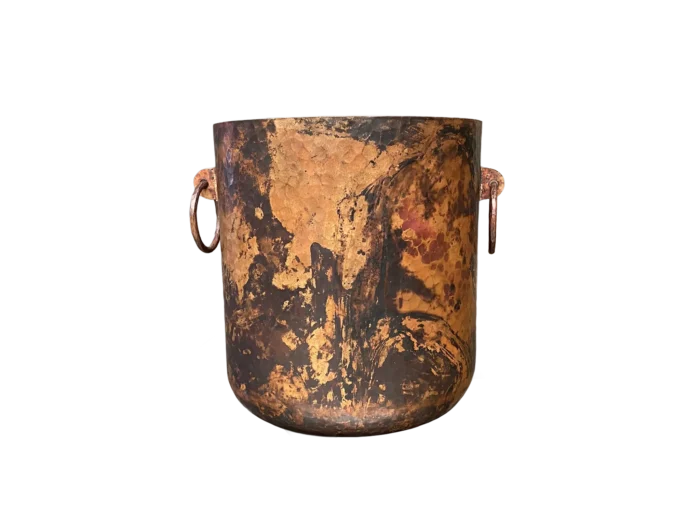 Back view of hand-hammered copper cooler with single forged handle, rustic luxury barware with patina finish.