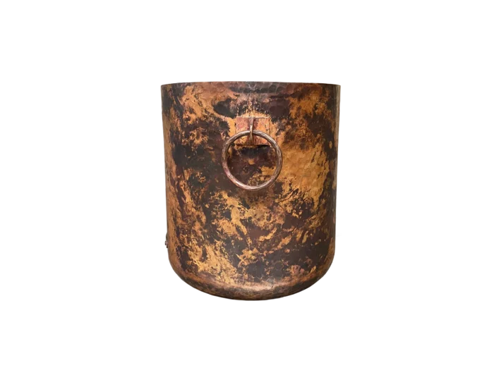 Side angle of rustic copper cooler with forged ring handles, artisanal hammered ice bucket for wine or champagne.