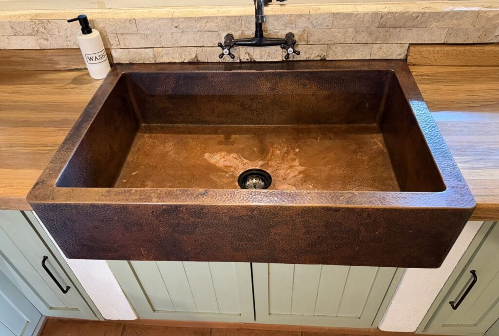 Handcrafted copper kitchen sink in a refined residential kitchen